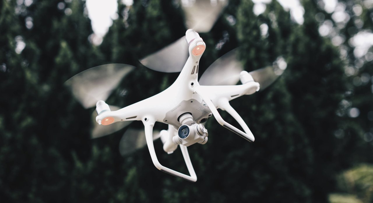 DJI Phantom 4 飞行姿态，展示了相机在机身下方的集成位置