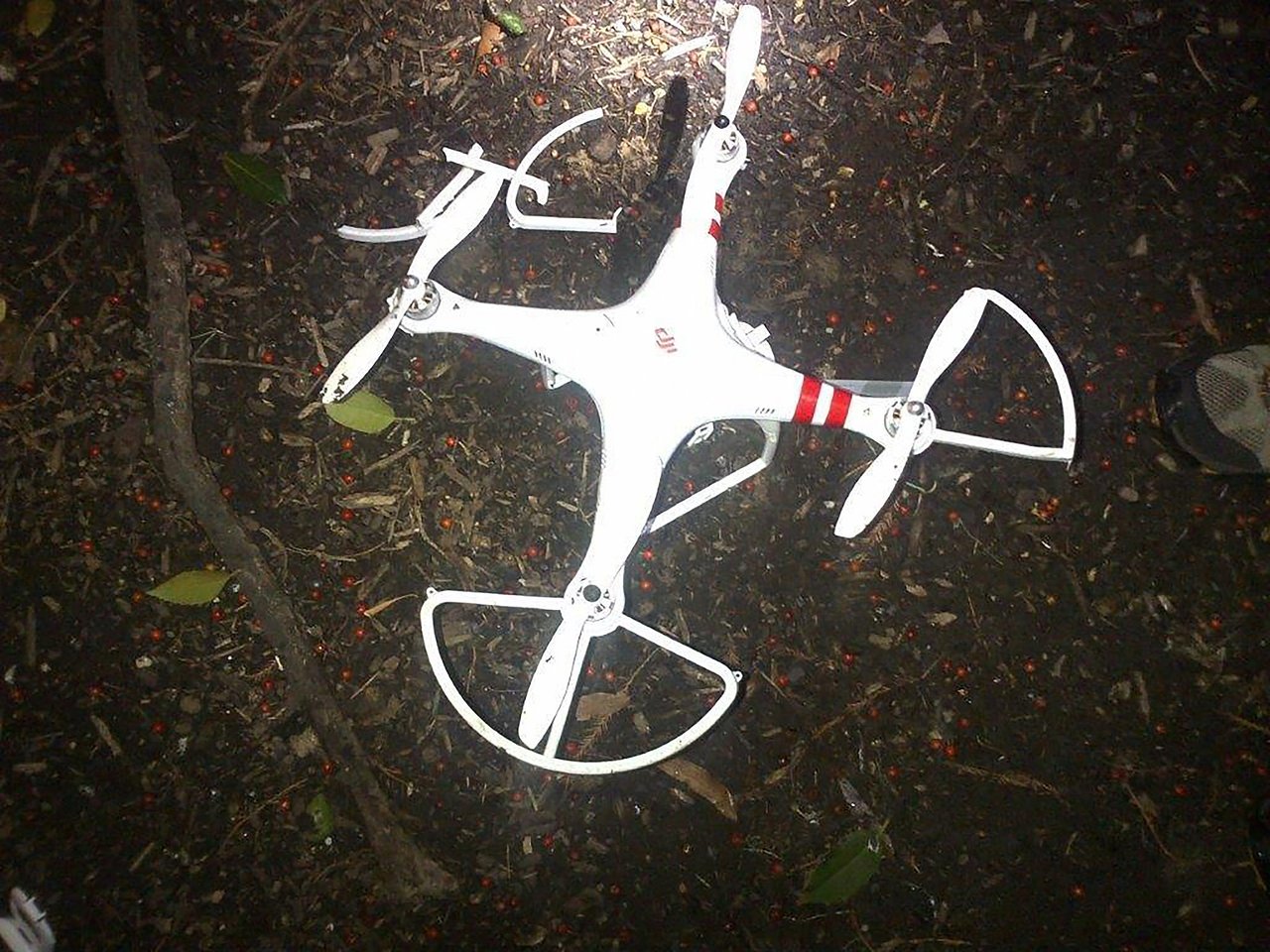 Secret Service 发布的坠机现场照片，一架白色 DJI Phantom 躺在白宫南草坪枯叶和碎石中