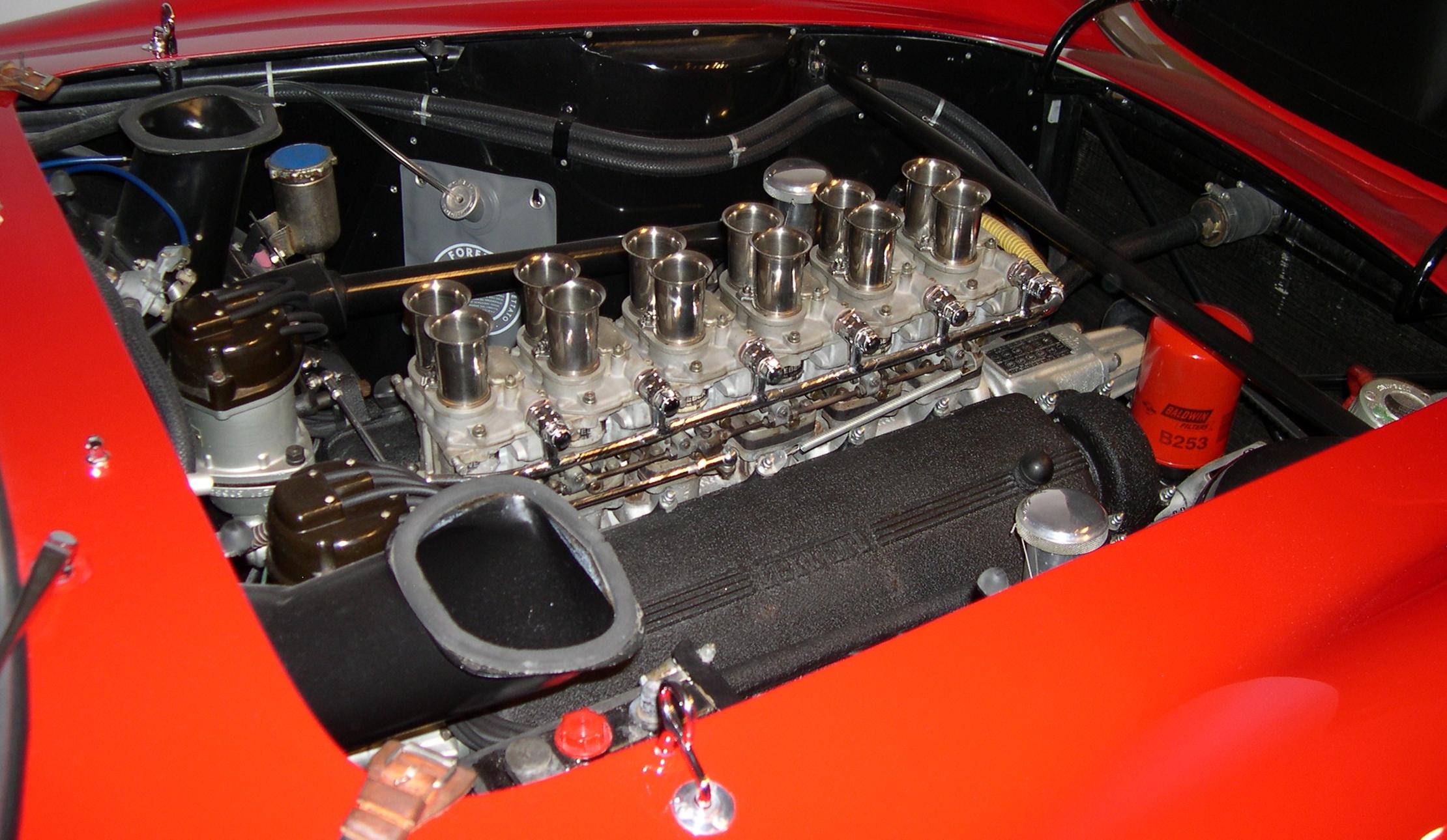 1962 Ferrari 250 GTO 的 Colombo V12 引擎特写，可见六组 Weber 化油器和银白色铝制缸体