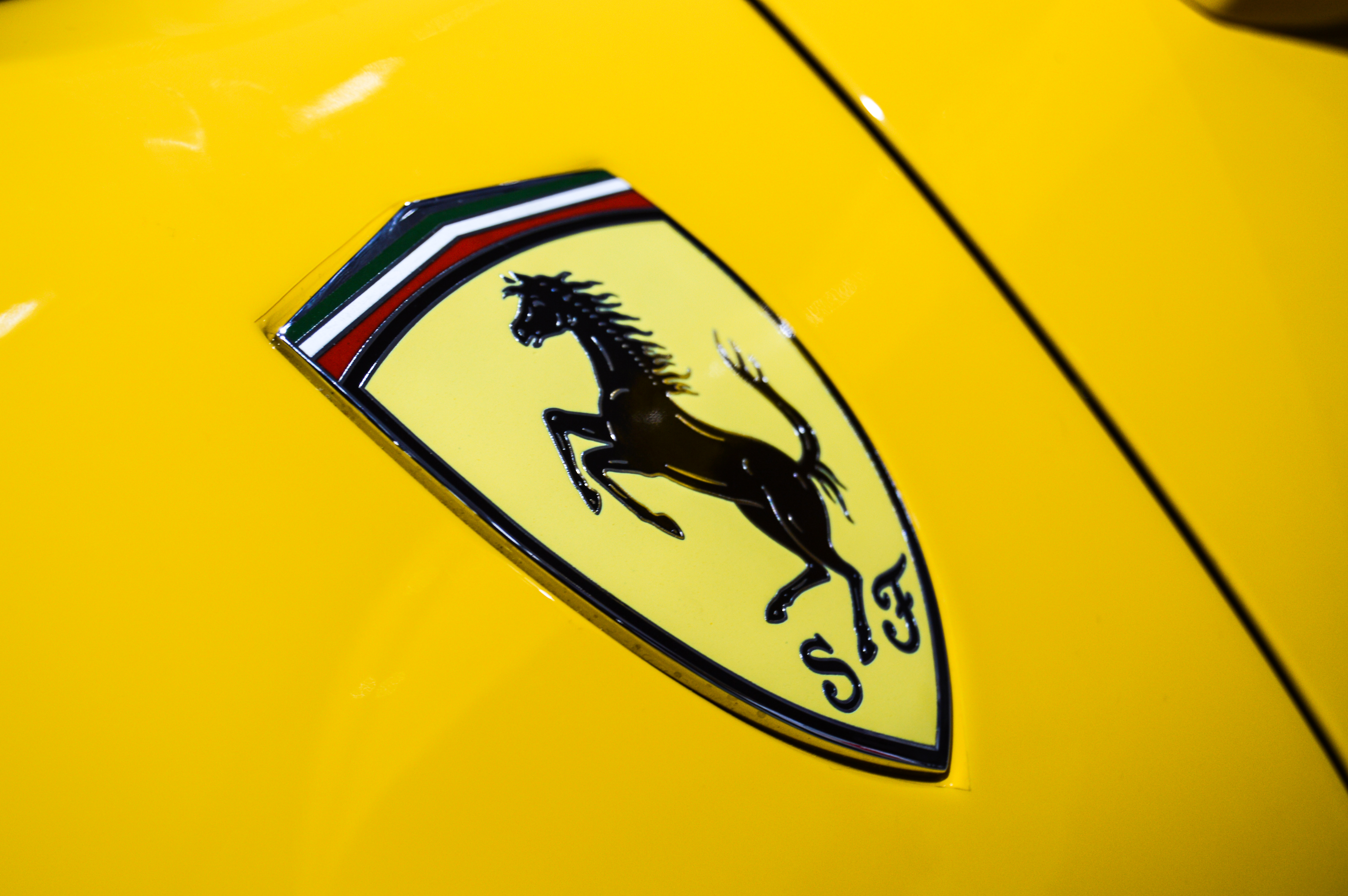 1947 年 Ferrari 125 S 上首次使用的矩形徽章，黄色背景上的黑色跃马，面朝左侧