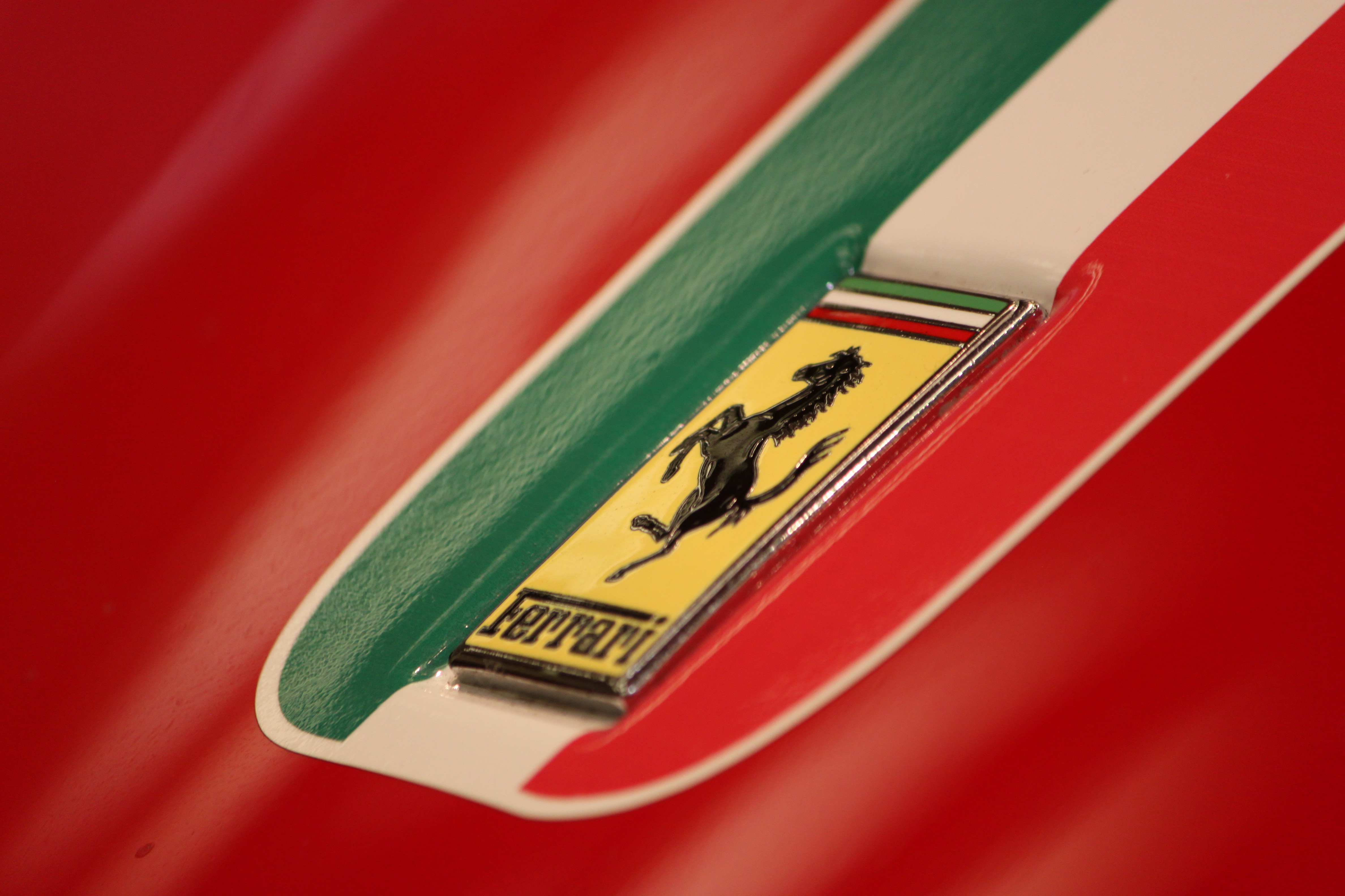现代 Ferrari 488 GTB 车身上的 Scuderia Ferrari 盾牌徽章特写，展示黄色底色和 S.F. 字母