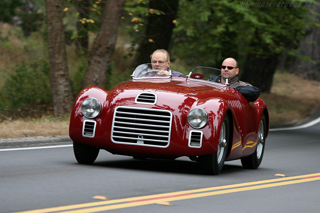 1947 Ferrari 125 S 在场地外行驶的展示图，两名乘员坐在车内