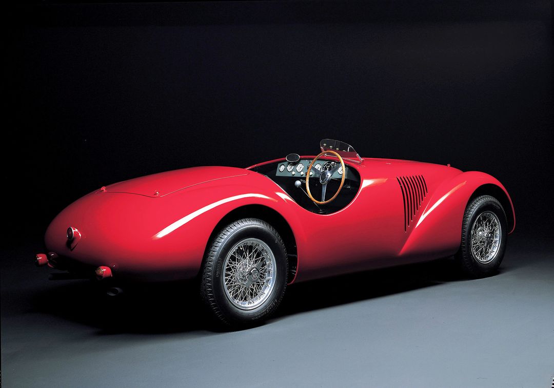 Ferrari 官方拍摄的 125 S 展示图，暗色背景上的红色车身凸显品牌原点的视觉力量