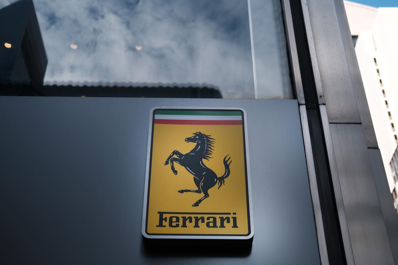 Ferrari CEO Benedetto Vigna 在 E-Building 内的留影，背景可见新能源动力总成展示墙