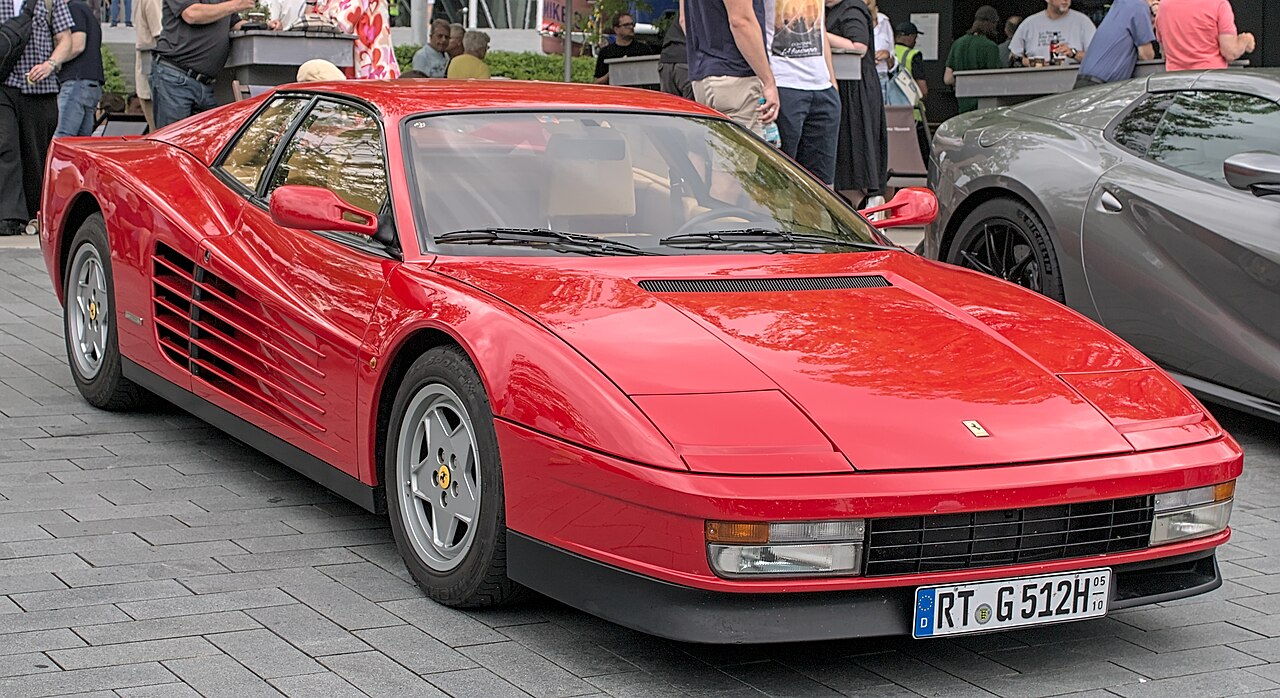 Ferrari Testarossa 侧面特写，展示从车门到尾灯排布的十条水平散热条和楔形车身轮廓
