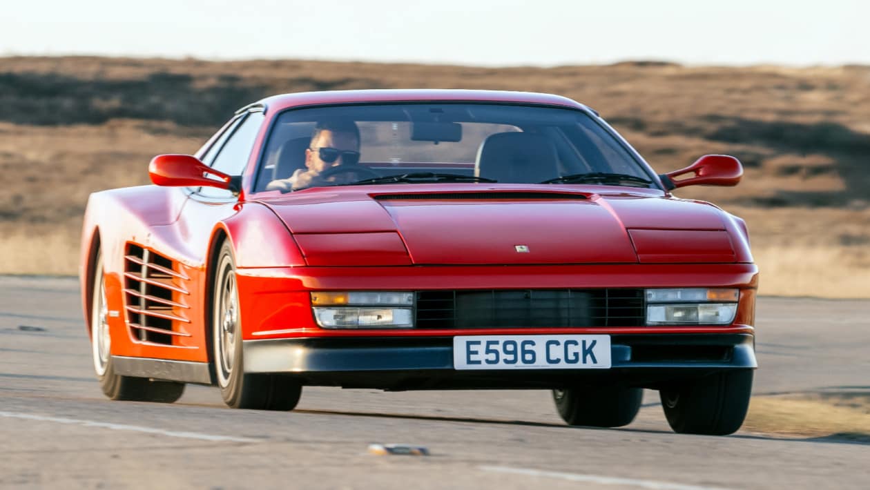Ferrari Testarossa 在巴黎车展上的展示照片，红色车身、弹出式头灯和 Pininfarina 设计的低矮楔形前脸
