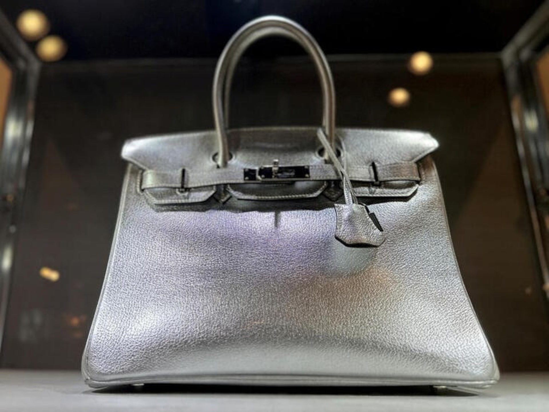 Birkin 包在玻璃展柜中的展示，作为诉讼新闻配图