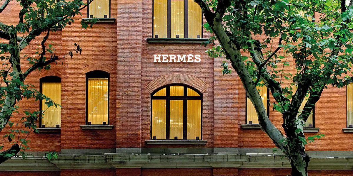 Hermès 上海 Maison 内景，皮革饰面玻璃展示柜和弧形楼梯