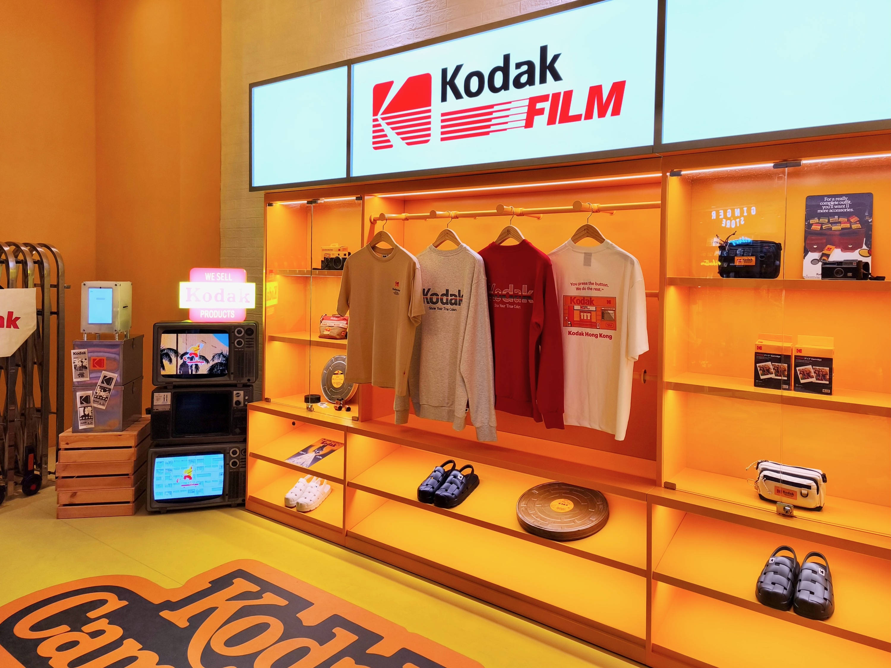 Kodak 授权产品零售陈列：服装、配饰和 vintage 相机装饰的组合展示