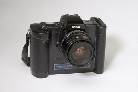 Kodak Ecam 1989 年原型机，名为 Ecam (Electronic Camera) 或 D-5000，黑色机身配蓝色组件，顶部显示屏标着 "Megapix 131"