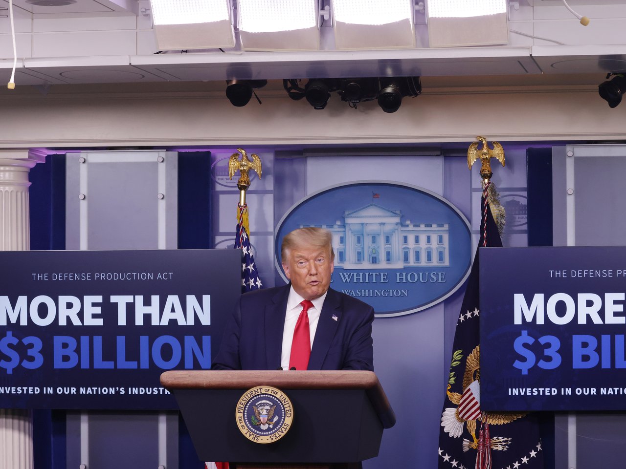 Trump 在白宫简报会上宣布 Kodak 获得 $765M DFC 贷款，背景为 Kodak 和 DFC 标志