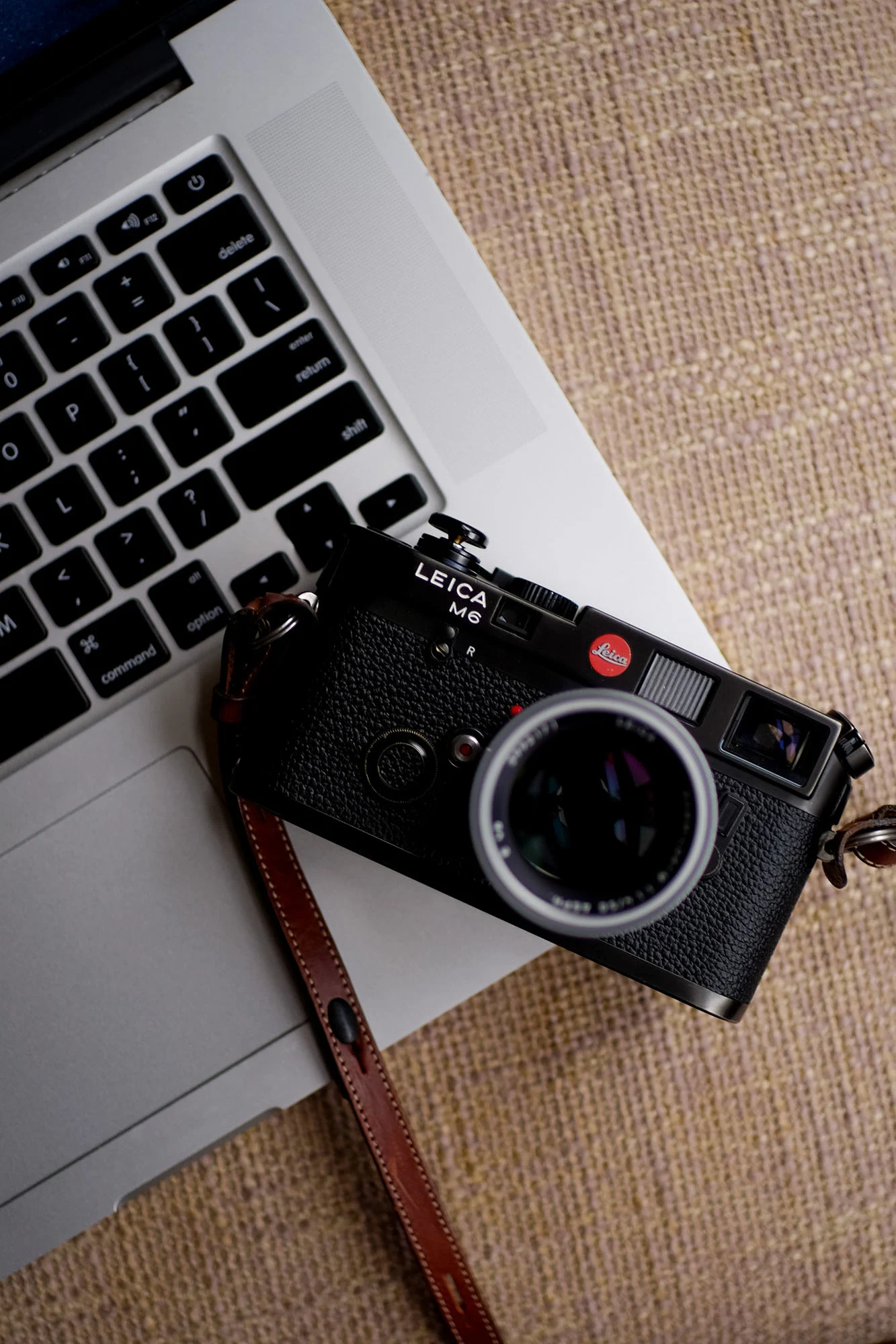 Leica M6 正面，黑色机身，展示经典 M 系列前脸三窗口布局和顶板线条