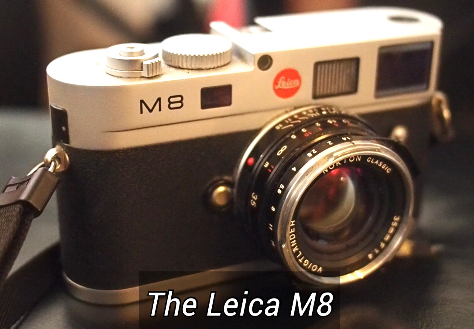Leica M8 机身正面，银色顶盖、黑色饰皮，搭载一支 Elmarit-M 21mm 镜头