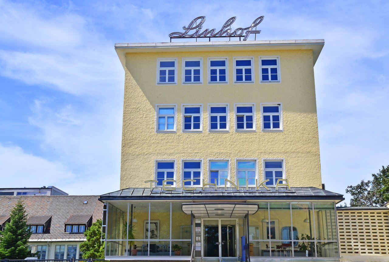 慕尼黑 Linhof Präzisions-Systemtechnik GmbH 总部建筑，黄色外墙和屋顶的 Linhof 标识清晰可见