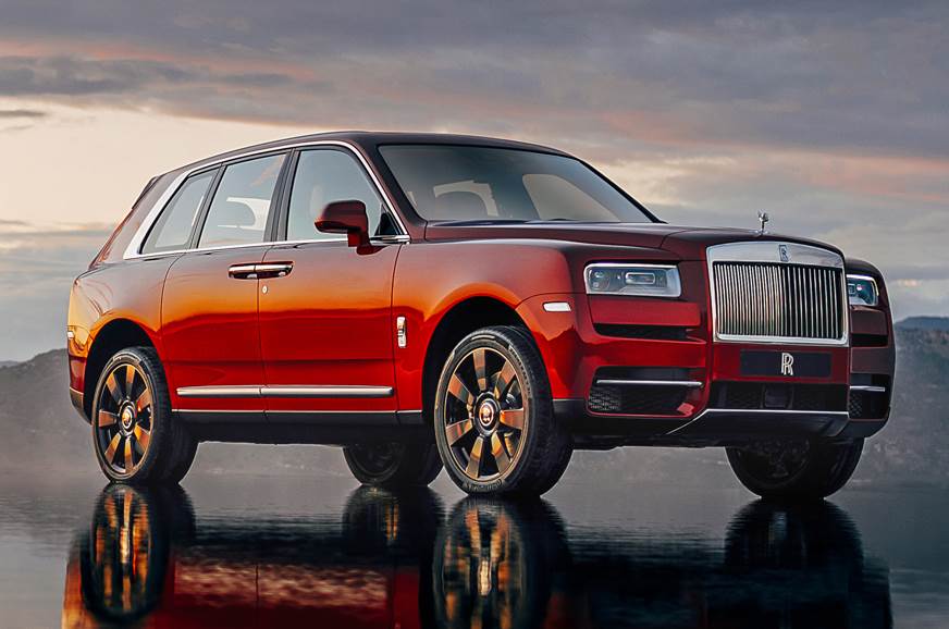 Rolls-Royce Cullinan 前侧视角，红色车身停在日落背景中